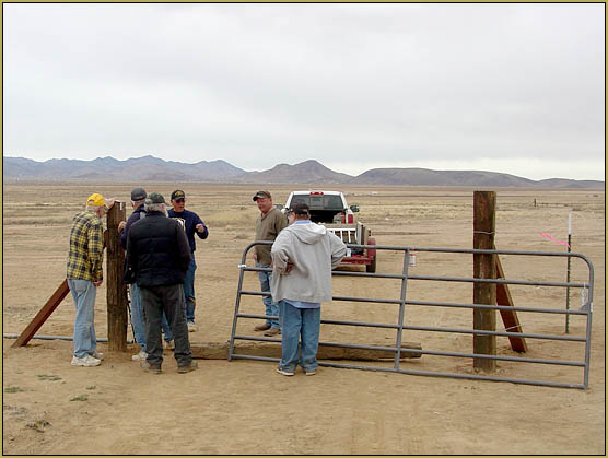 Bunch of guys deciding to hang the gate from the left-hand post.