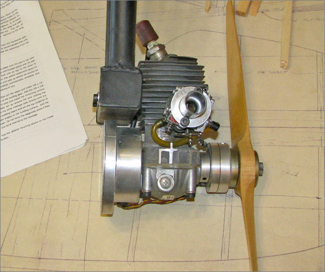 The 38cc Zenoah 2-stroke engine with a custom muffler.